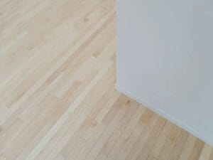 an empty room with hard wood floors and white walls